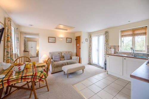a kitchen and living room with a couch and a table at The Cartlodge Boundary Farm, Framlingham in Woodbridge