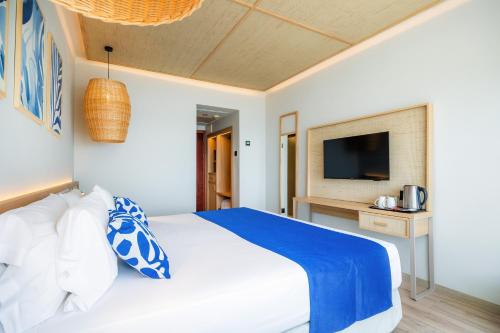 a bedroom with a large bed with a television at Marins Suites - Adults Only Hotel in Cala Millor