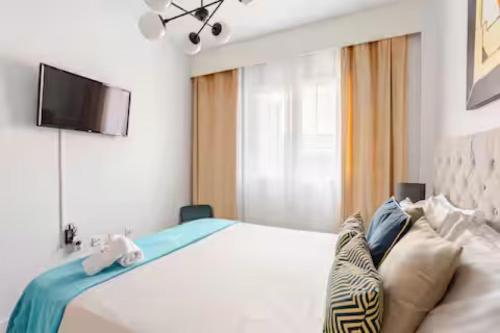 a bedroom with a bed with a television on the wall at Sunset Gabriela in Candelaria