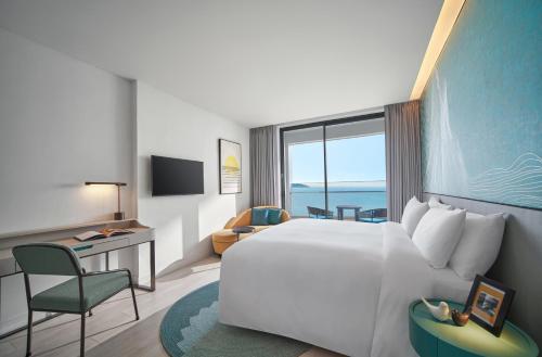 a hotel room with a bed and a desk and chair at voco Ma Belle Danang by IHG in Da Nang