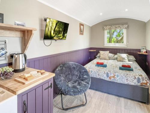 Un dormitorio con una cama y un televisor en la pared. en Valley View Retreats- West Down Farm Estate, en North Molton