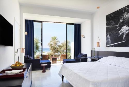 a bedroom with a bed and a view of the ocean at Almyra in Paphos City