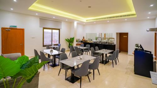 Un restaurante con mesas y sillas y un mostrador. en Express City Hotel - Duqm, en Duqm