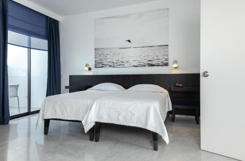 a bedroom with a large bed with white sheets at Almyra in Paphos City
