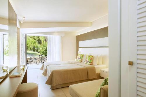 a hotel room with two beds and a balcony at Makryammos in Limenas