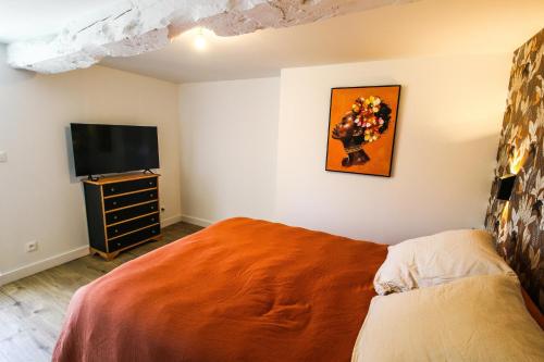 a bedroom with a bed and a flat screen tv at Les Rêveries de Tinténiac in Tinténiac