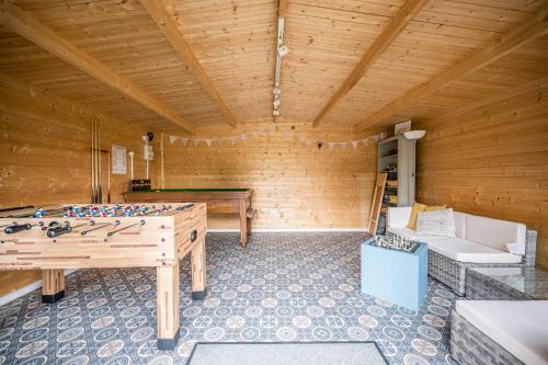 a room with a ping pong table in a wooden room at The Cartlodge Boundary Farm, Framlingham in Woodbridge