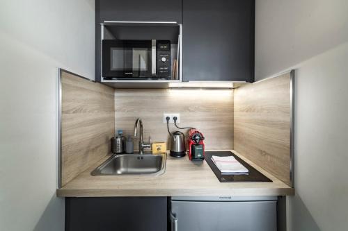 une cuisine avec un évier et un micro-ondes dans l'établissement Studio Hypercentre avec vue sur le vieux Lyon AIL, à Lyon