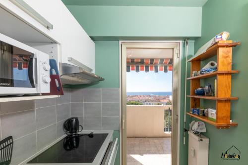 a kitchen with a sink and a view of the ocean at L'estivalière in Golfe-Juan