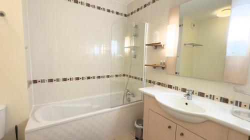 a bathroom with a tub and a sink and a bath tubermottermott at Studio climatisé à Divonne-les-Bains in Divonne-les-Bains