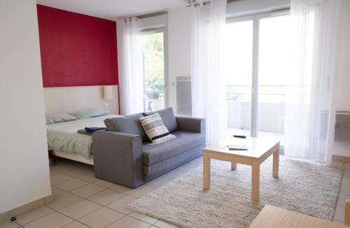 a living room with a couch and a bed at Studio climatisé à Divonne-les-Bains in Divonne-les-Bains
