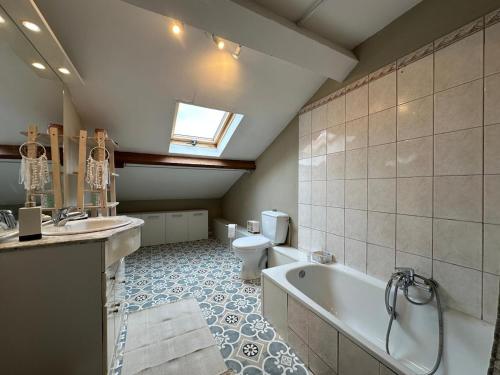 a bathroom with a tub and a toilet and a sink at Le Neuvillois, Charming house 6p in Neuville-sous-Montreuil