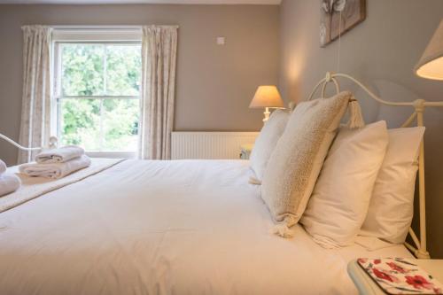 a bedroom with a large white bed with a window at The Farmhouse Boundary Farm Framlingham in Woodbridge