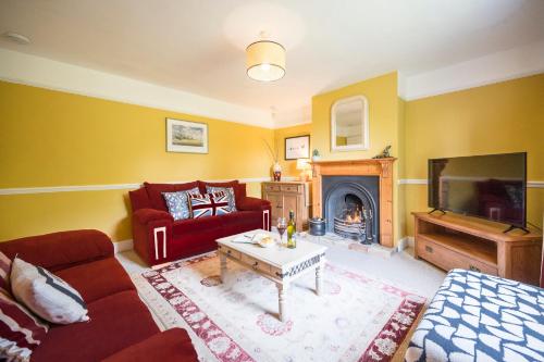 a living room with a couch and a fire place at The Farmhouse Boundary Farm Framlingham in Woodbridge