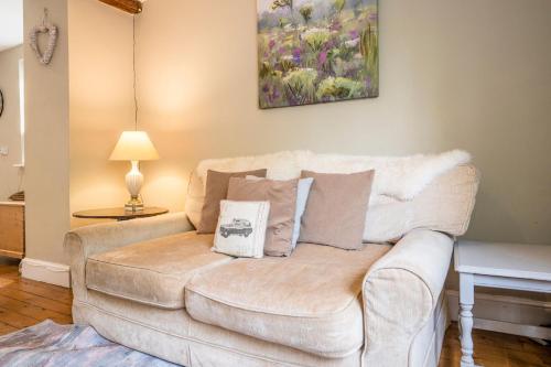 a living room with a white couch with pillows at The Farmhouse Boundary Farm Framlingham in Woodbridge