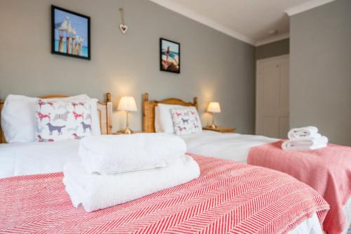 a bedroom with two beds with towels on the bed at The Farmhouse Boundary Farm Framlingham in Woodbridge