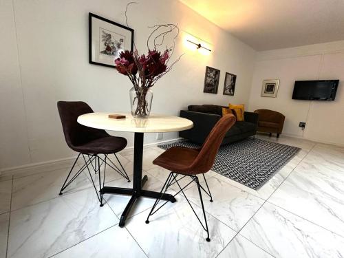 Una sala de estar con una mesa y sillas y un sofá. en Cozy nest in the town city, en Vosburg