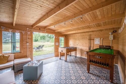 a room with a pool table in a wooden room at The Farmhouse Boundary Farm Framlingham in Woodbridge
