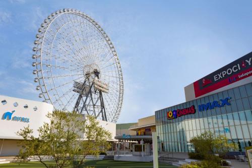a large ferris wheel in front of a mall at Minamisenri Crystal Hotel in Suita