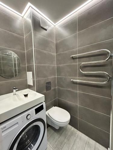a bathroom with a washing machine and a toilet at Baika's SELF check-in apart in Klaipėda
