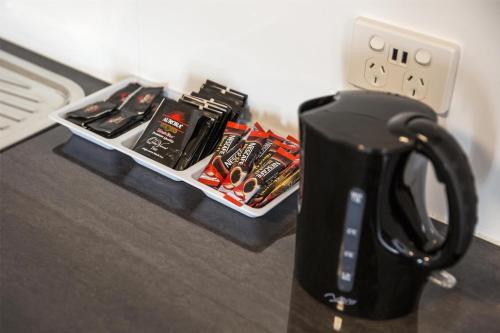 a black coffee mug sitting on a table next to a tray of tools at Nightcap at Waltzing Matilda Hotel in Springvale
