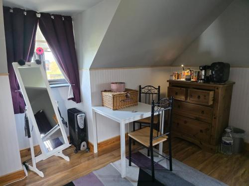 a room with a vanity and a dresser and a mirror at Kayleighs Room in Killinick