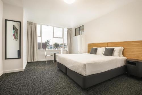 a hotel room with a large bed and a table at Nightcap at Waltzing Matilda Hotel in Springvale