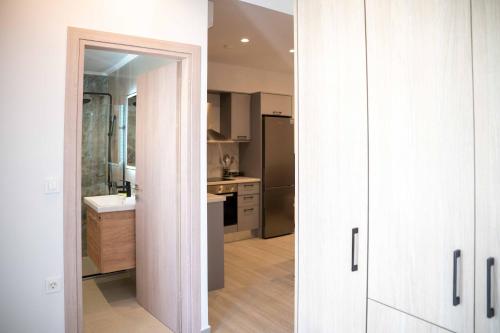 une cuisine avec des armoires blanches et un évier dans l'établissement The Cozy Twins, à La Canée