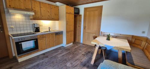a kitchen with wooden cabinets and a table and a stove at Appartement-Pension Familie Gewessler in Bad Mitterndorf