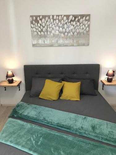 a bedroom with a bed with two yellow pillows at Superior Apartman Vujević, Duće in Duće