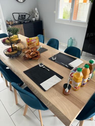 - une table en bois avec de la nourriture et des boissons dans l'établissement Chambre chez l'habitant avec piscine 400m Circuit 24h Le Mans, au Mans