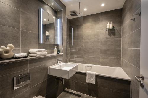 a bathroom with a sink and a bath tub at The Wellington Glasgow by Adina in Glasgow