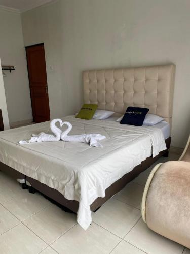 a bed with two towels on top of it at Urbanview Resort Syariah Khansa Cisarua Puncak by RedDoorz in Tagalbato