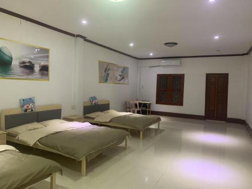 una habitación con tres camas en una habitación en FUBON World, en Vientiane