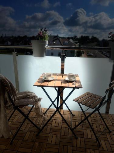 a wooden table and two chairs on a balcony at Apartament Poznańska 1 in Suwałki