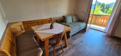 a living room with a table and a couch at Appartement-Pension Familie Gewessler in Bad Mitterndorf