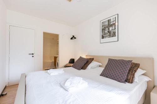 a bedroom with a large white bed in a room at Huswell - Bright & Stylish Apartment with Balcony in Knokke-Heist