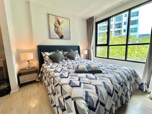 a bedroom with a bed and a large window at 1 Bedroom Condos Close to Shopping Malls in Ban Rangeng