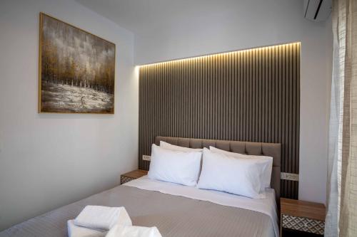 une chambre avec un lit avec un tableau sur le mur dans l'établissement The Cozy Twins, à La Canée