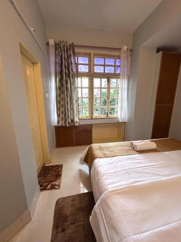 a bedroom with two beds and a window at The Dan Si in Guwahati