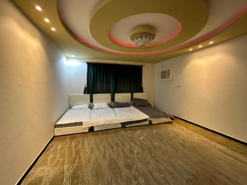 a bedroom with a large bed with a ceiling at شاليه هاشتاق الودي in Al Wudayy