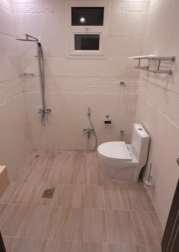 a bathroom with a toilet and a window at شقة بغرفة نوم وصالة in Buraydah