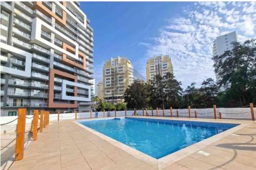 a swimming pool in front of a building at Elite 3F Portimão com mar, piscina e garagem in Portimão