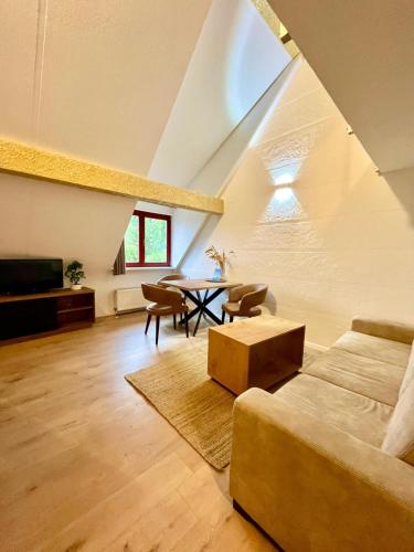 a living room with a couch and a table at Allgäuer Ferienwohnung mit Schwimmbad- und Sauna-Zugang in Wiggensbach