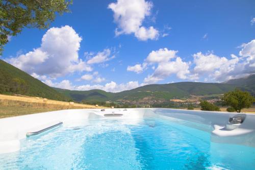 a swimming pool with mountains in the background at Agriturismo La Cascina di Opaco in Norcia