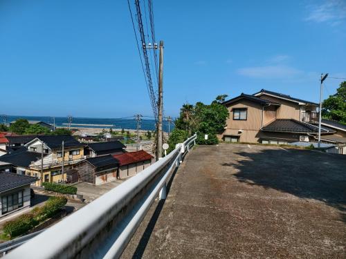 a view from the top of a hill with houses at 旅館青柳 海越し立山連峰の雪山絶景で休もう in Himi