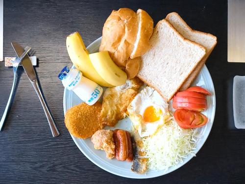 a plate of breakfast food with eggs bread and toast at 旅館青柳 海越し立山連峰の雪山絶景で休もう in Himi