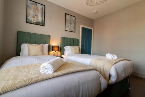 two beds in a hotel room with towels on them at LuNa Apartment-3bed Sleeps 6 - FamilyContractors in Elswick