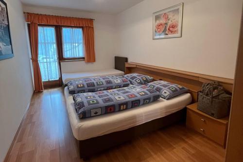 a bedroom with two beds and a window at Bruneggerhof Weissenbach in Rio Bianco