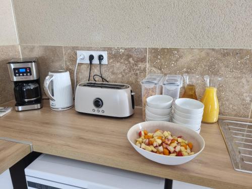 un comptoir avec un bol de nourriture et un grille-pain dans l'établissement L'Orée du Ventoux - Crillon-le-Brave, à Crillon-le-Brave